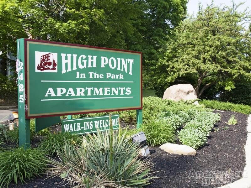 Green High Point in the Park monument sign - underneath smaller sign stating walk ins welcome surrounded by greenery and rocks.