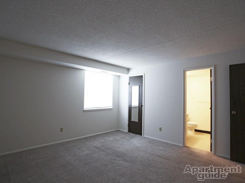 Bedroom with carpeting and door leading to bathroom