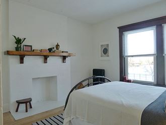 a bedroom with a fireplace and a window