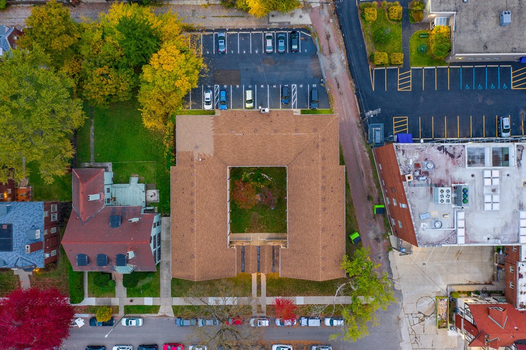 an aerial view of a brick building with a green roof