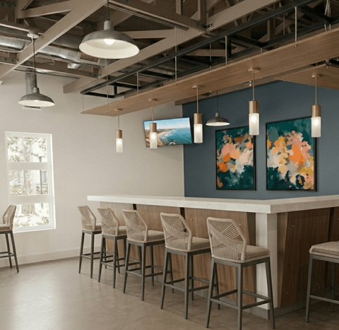 A bar area with a white counter and chairs.