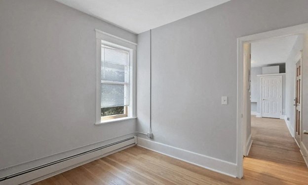 a living room with a window and a wooden floor