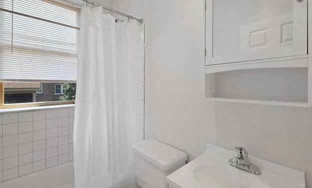 a bathroom with a sink and a toilet and a shower