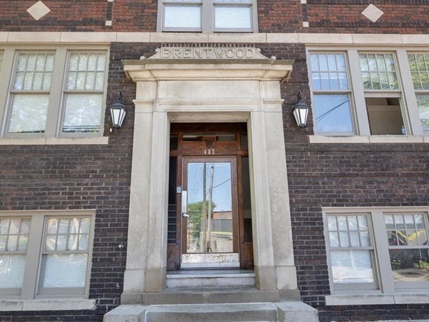 the front of a brick building with a wooden door