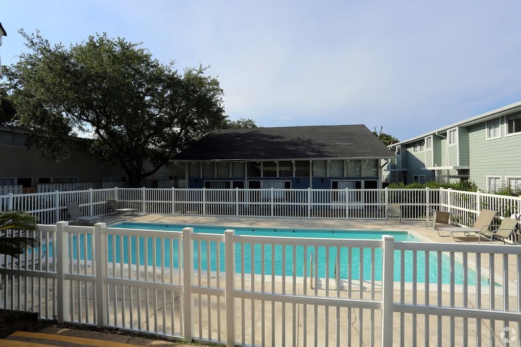 Outdoor pool with white fence.