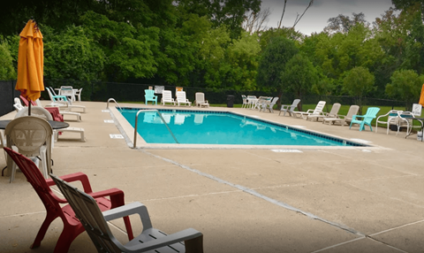 a swimming pool with chairs and chairs around it