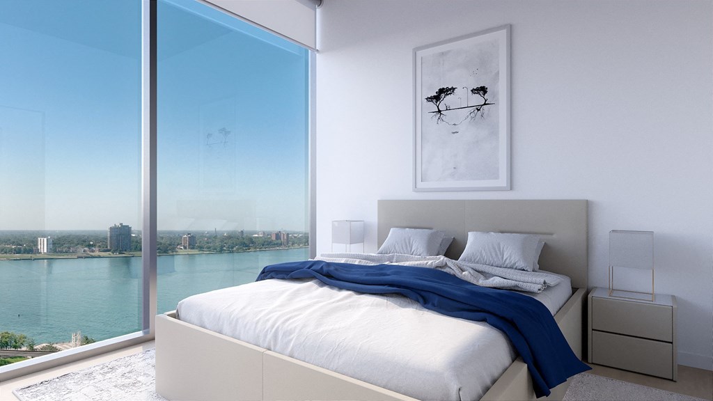 a bedroom with a large window and a view of a body of water