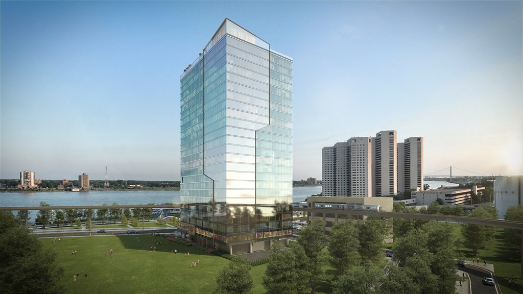 an aerial view of a glassy skyscraper in front of a body of water