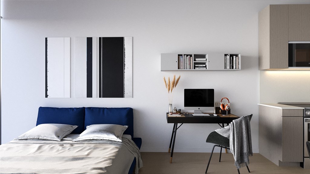 a bedroom with a bed and a desk with a computer