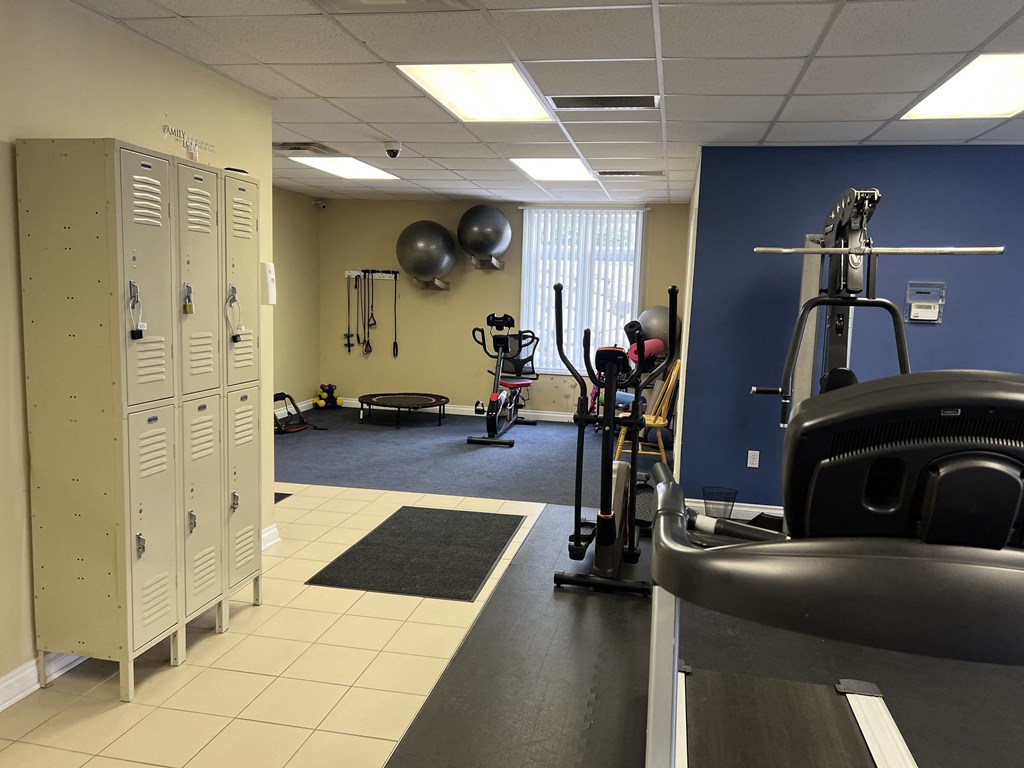 a fitness room with cardio equipment and lockers