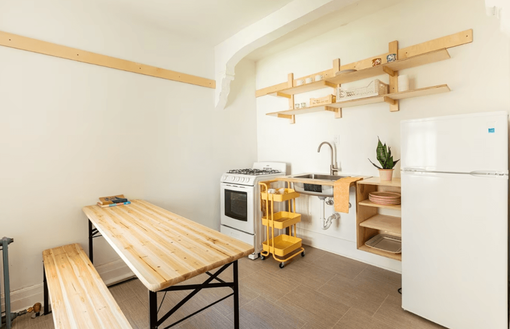 a kitchen with white appliances and a wooden table