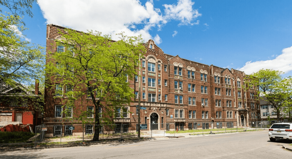 a large brick building with a tree in front of it