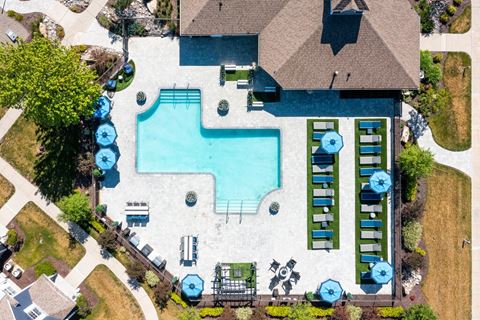 arial view of a pool and a house with a roof