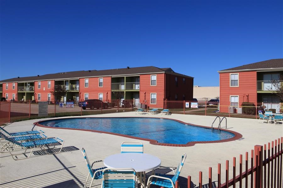 Outdoor sparkling swimming pool and expansive sundeck with pool furniture at Forest View.