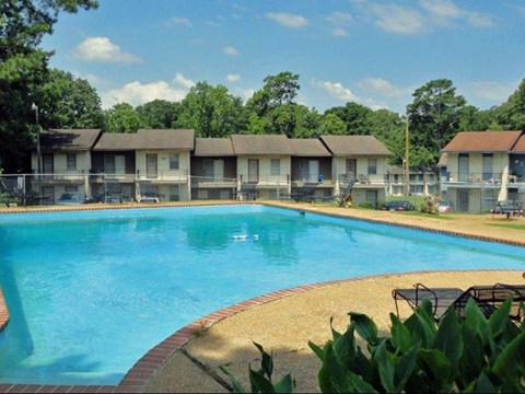 a large swimming pool with apartments in the background