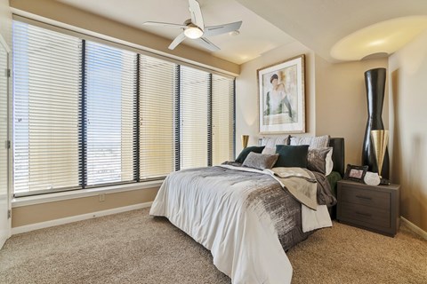 A bedroom with a bed, nightstand, and a ceiling fan.