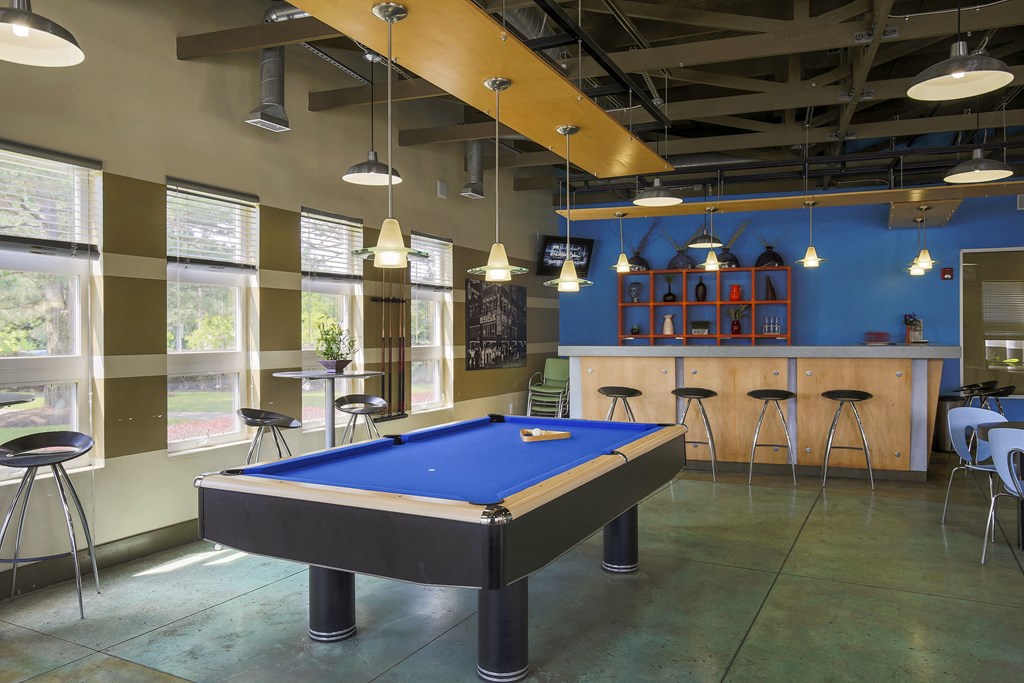 a game room with a blue pool table and a bar at Village Club of Rochester Hills, Shelby Township
