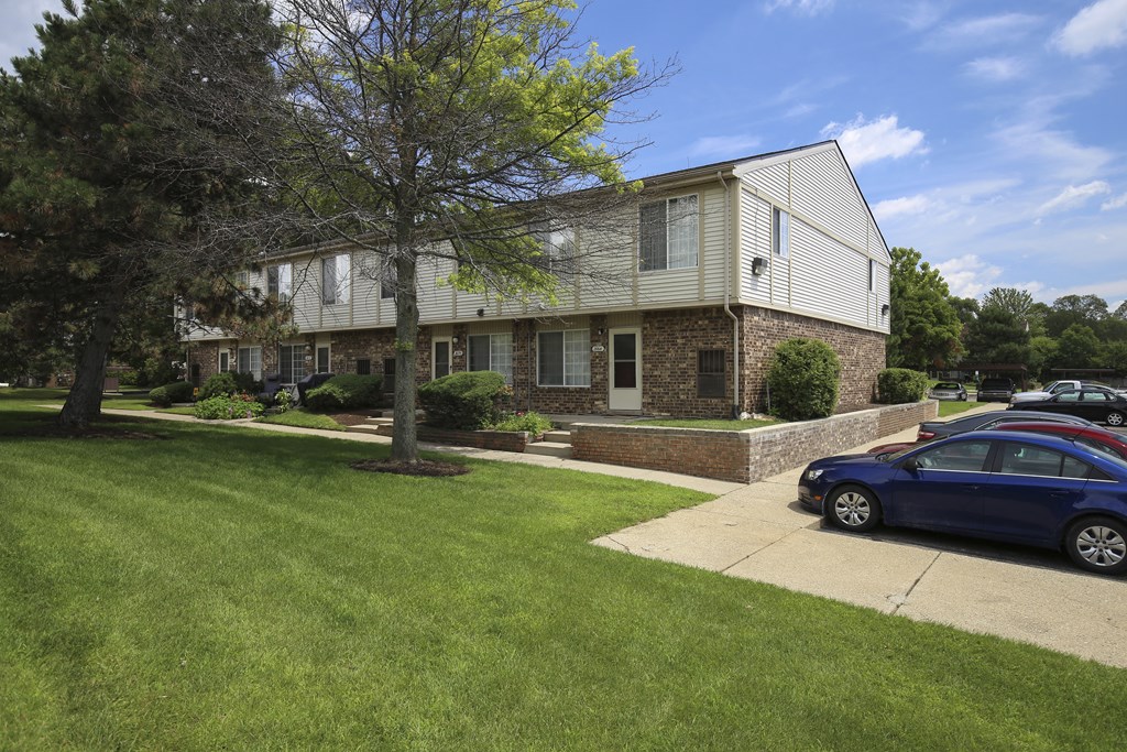 a house with a blue car parked in front of it at Village Club of Rochester Hills, Shelby Township, 48317