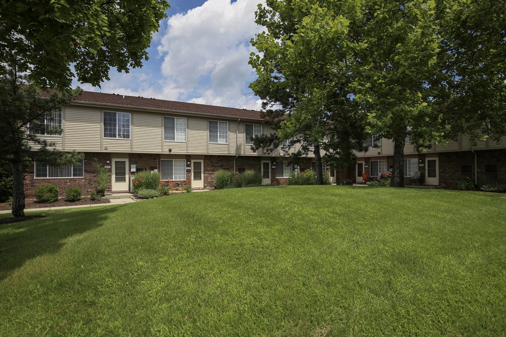 our apartments are located in a large grassy area with trees at Village Club of Rochester Hills, Shelby Township, MI