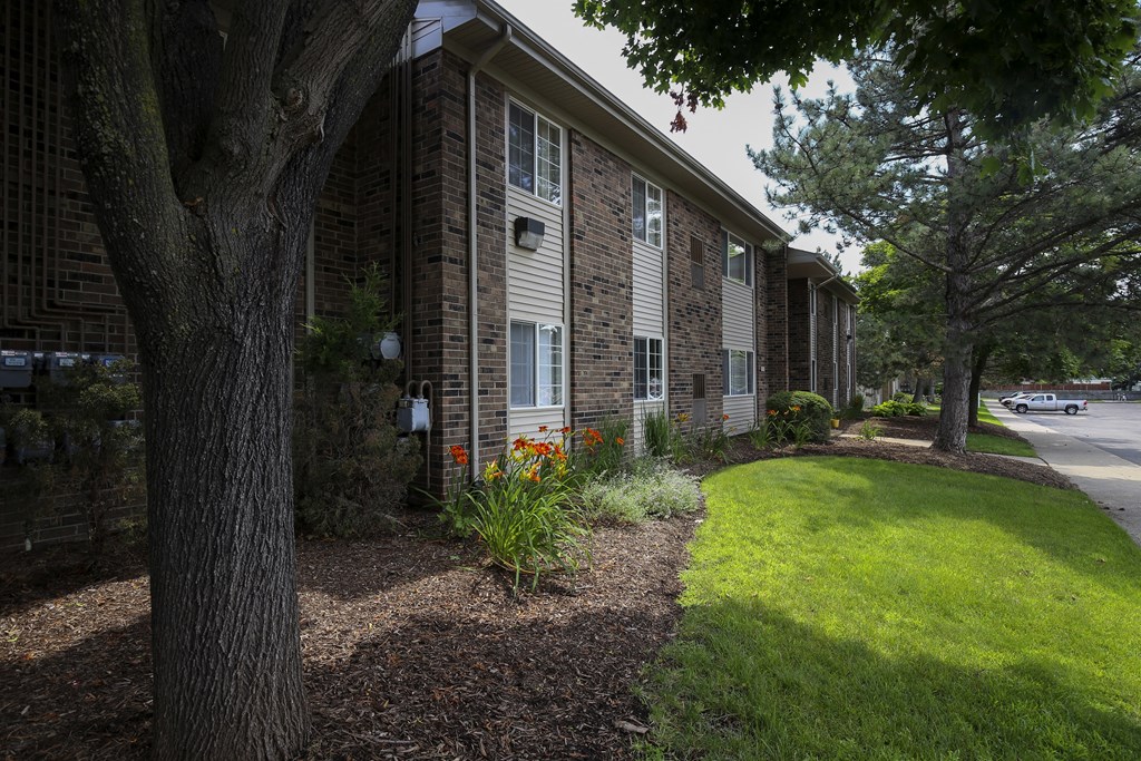side view of the building with a lawn and trees at Village Club of Rochester Hills, Shelby Township Michigan