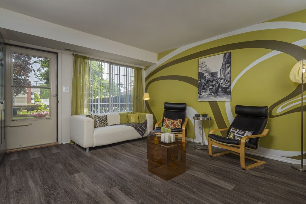 a living room with yellow walls and a couch and chairs at Village Club of Rochester Hills, Michigan