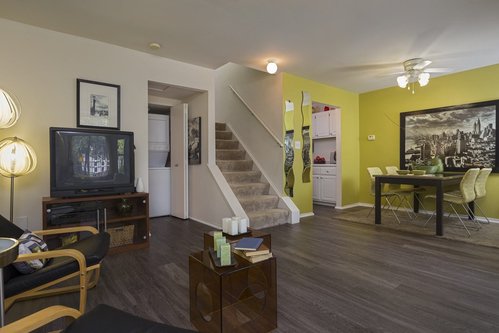 a living room with yellow walls and a staircase at Village Club of Rochester Hills, Michigan, 48317