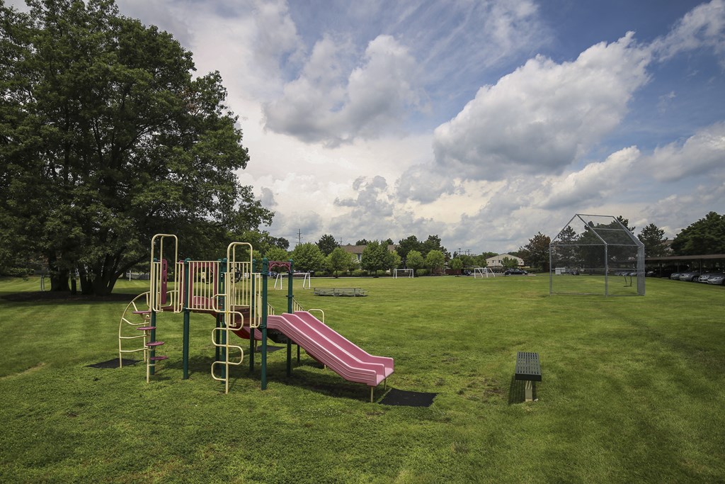 a playground with a slide and a bench in a park at Village Club of Rochester Hills, Shelby Township Michigan
