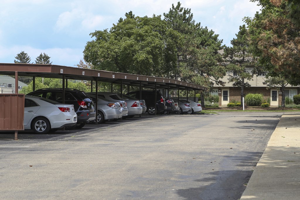 a row of cars parked under a roof in a parking lot at Village Club of Rochester Hills, Shelby Township
