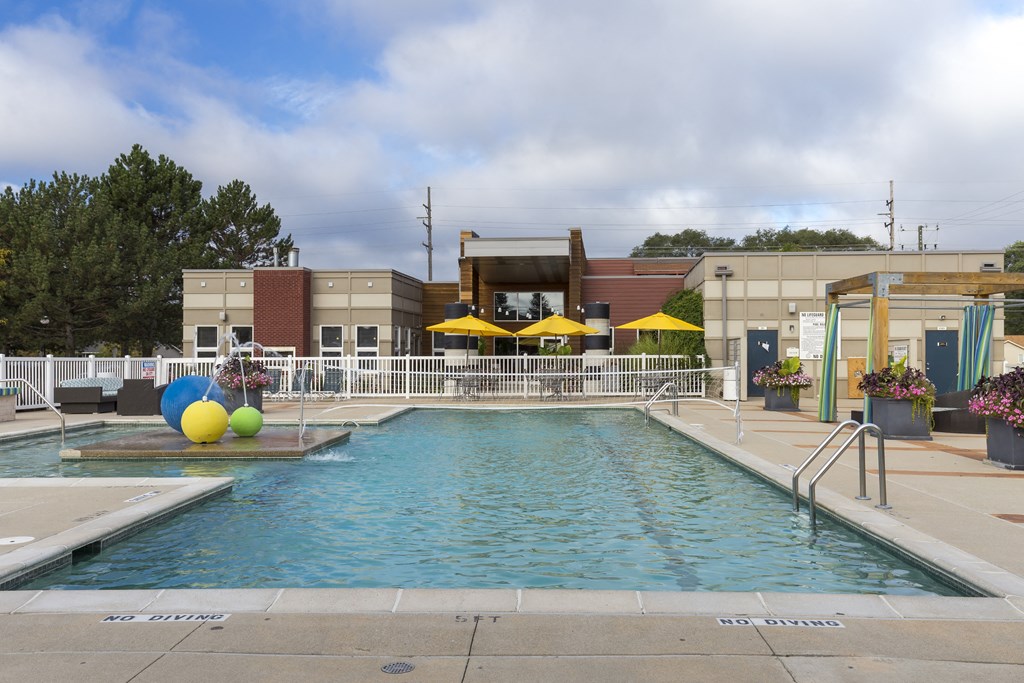 a swimming pool with a building in the background at Village Club of Rochester Hills, Shelby Township, MI