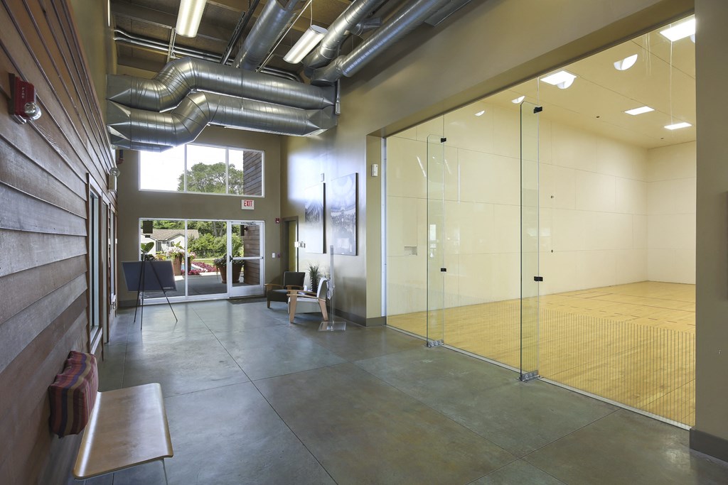 a large room with glass doors and a ping pong table at Village Club of Rochester Hills, Shelby Township