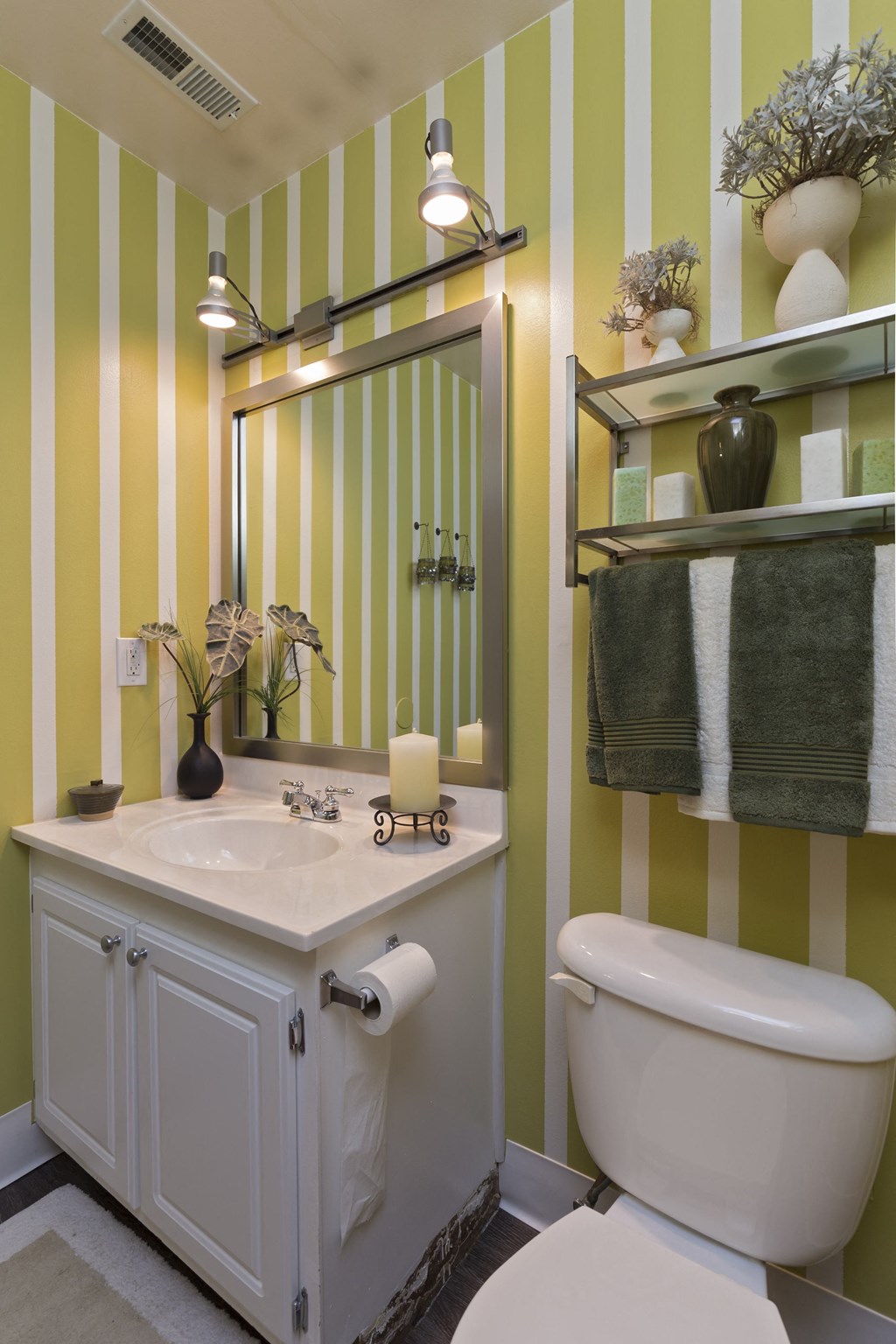 a bathroom with yellow and white striped walls and a white toilet at Village Club of Rochester Hills, Shelby Township, 48317