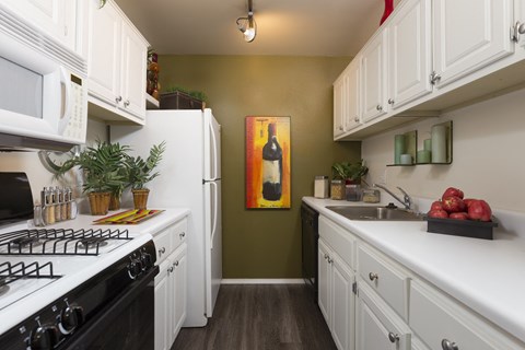 a kitchen with white cabinets and a stove and a refrigerator