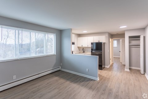 A kitchen with a black fridge and white cabinets.