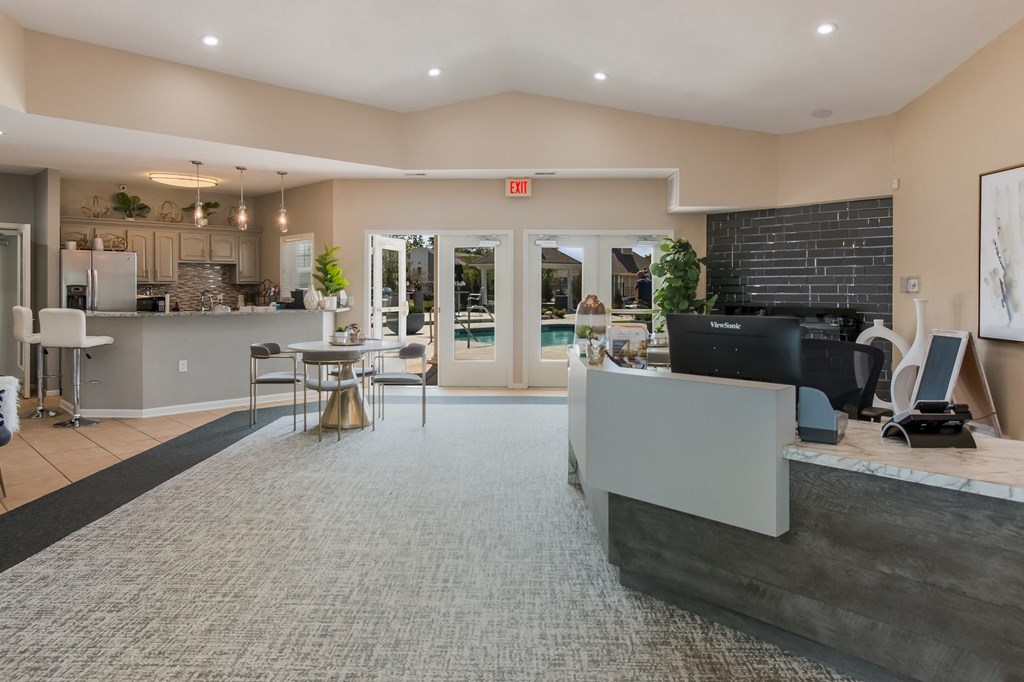 a clubhouse with a reception desk and a kitchen with a table and chairs