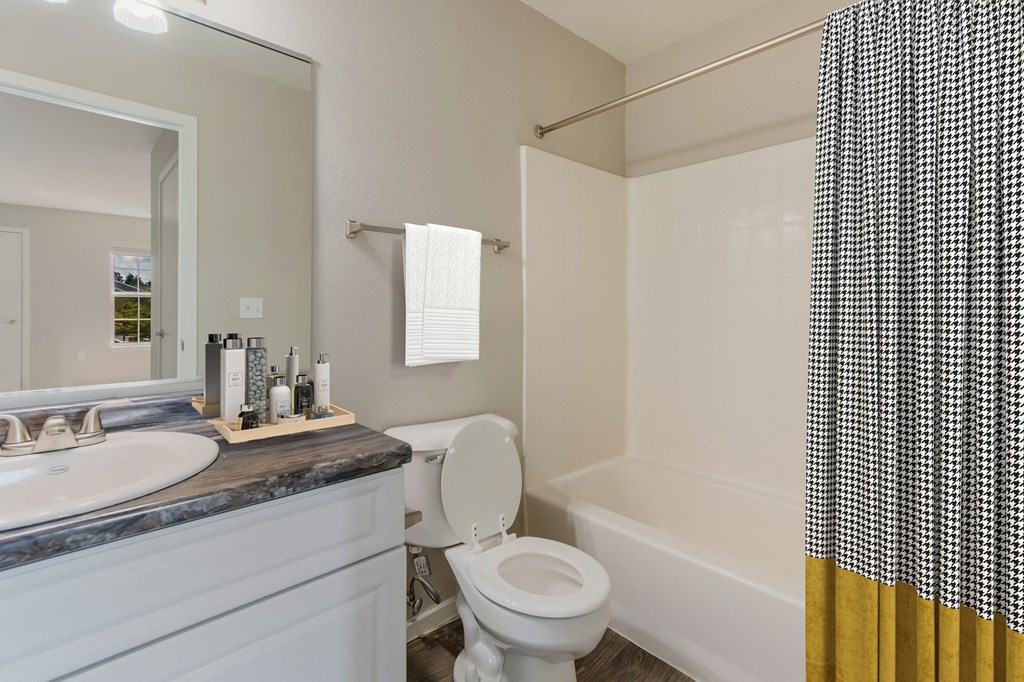a bathroom with a toilet and a sink and a bath tub
