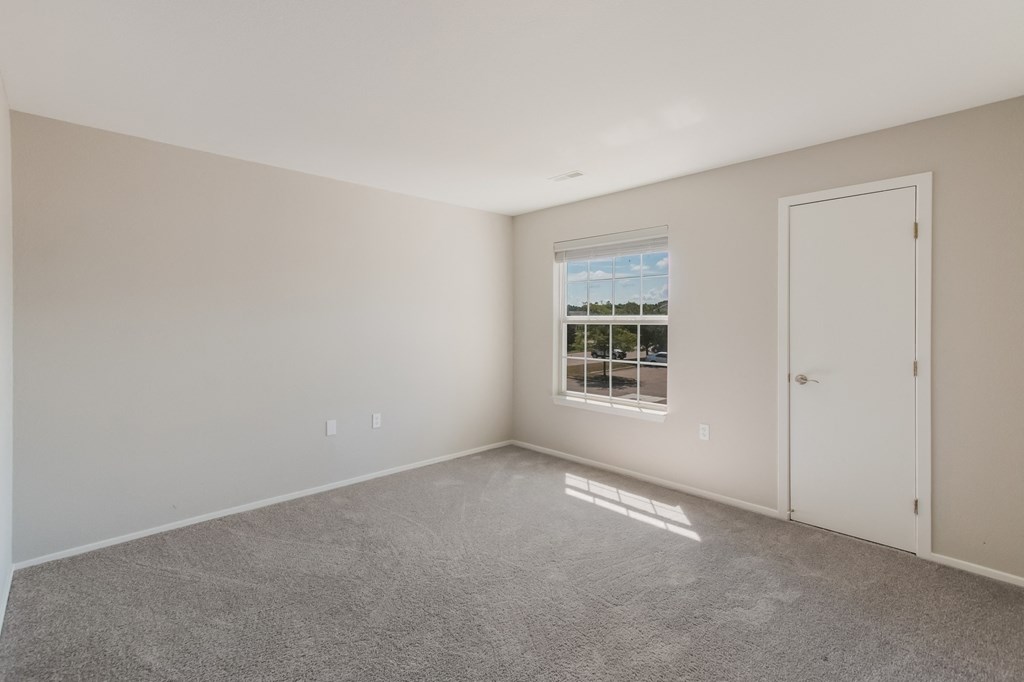 an empty room with a window and a door