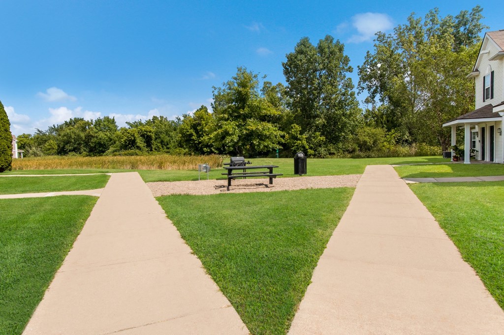 a park with a bench in front of a house