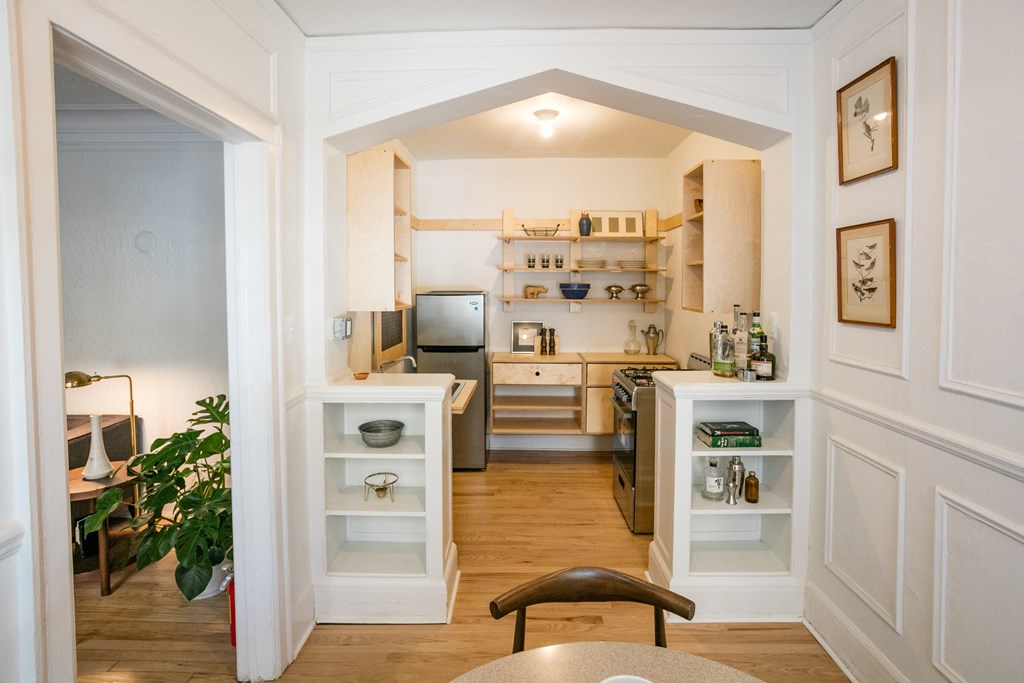 a view into a kitchen from a dining room with a table and chairs
