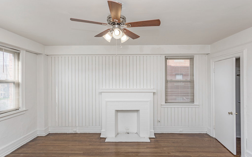 a bedroom with a ceiling fan and a fireplace