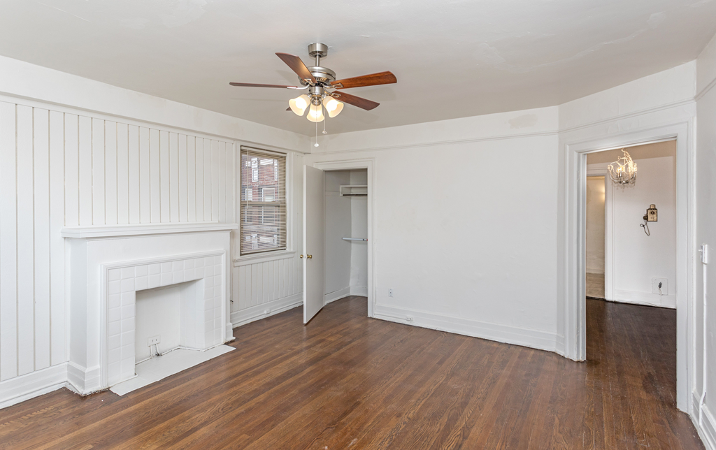 a bedroom with hardwood floors and a ceiling fan