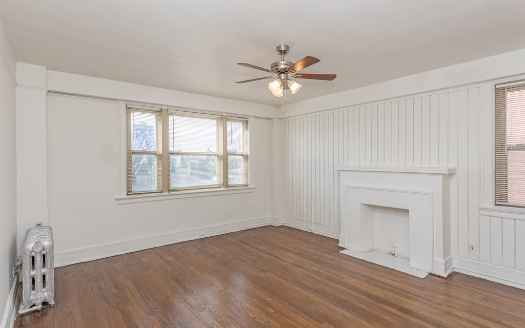 a bedroom with hardwood floors and white walls