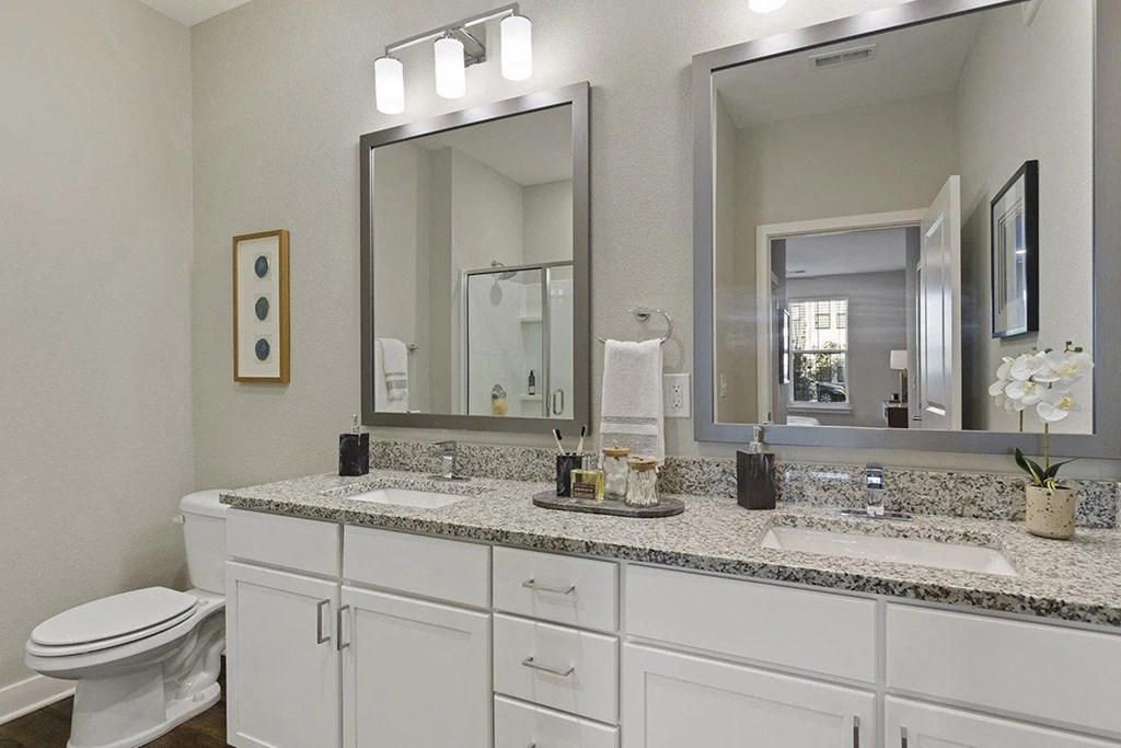 a white bathroom with two sinks and a mirror