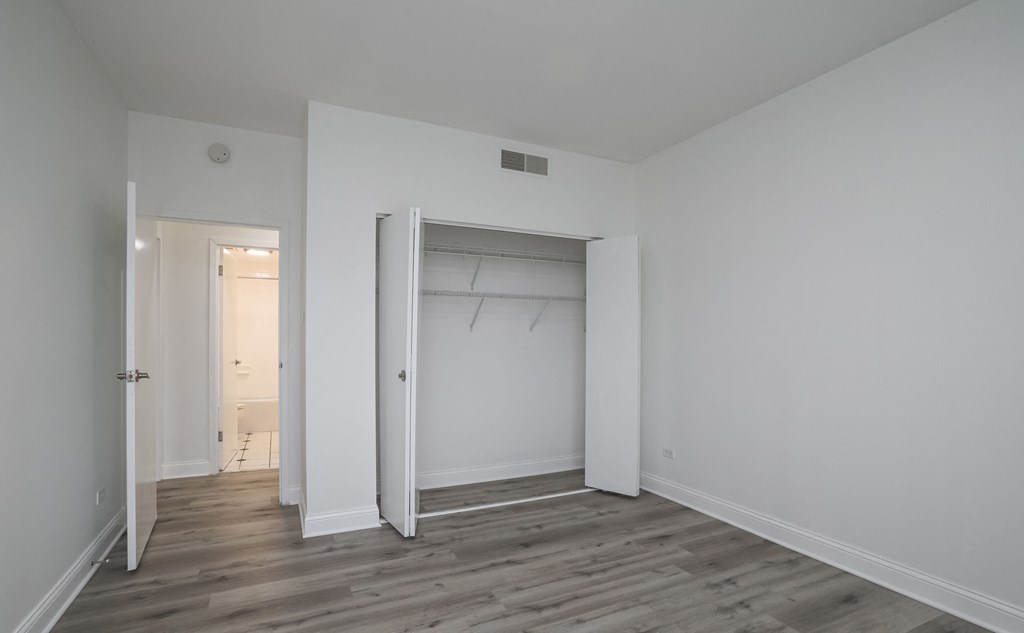 a bedroom with white walls and a closet with a white door