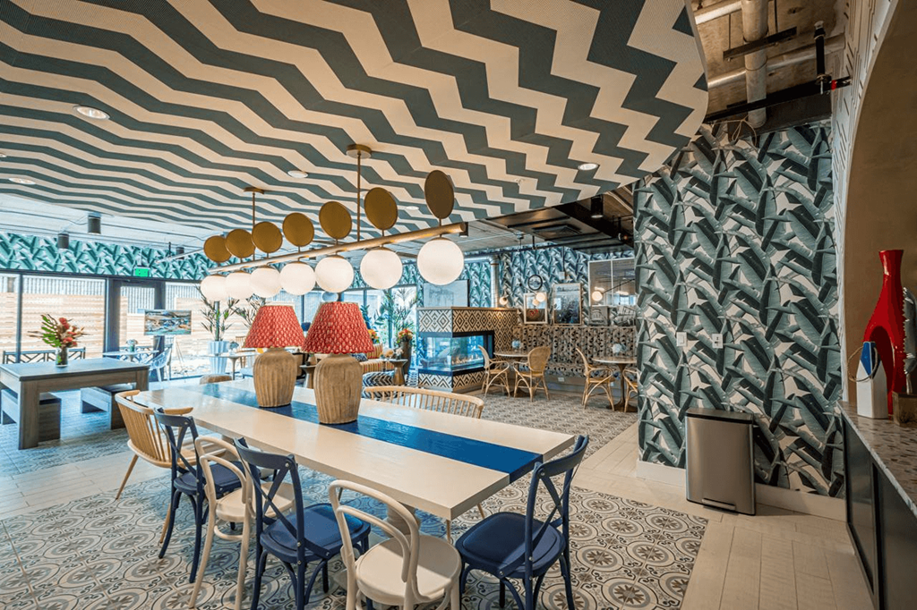 a dining room with a table and chairs and a geometric ceiling at City Club Apartments Lafayette Park, MI 48207