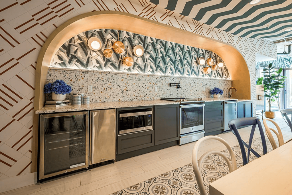 a kitchen with stainless steel appliances and a geometric wallpaper at City Club Apartments Lafayette Park, Michigan 48207