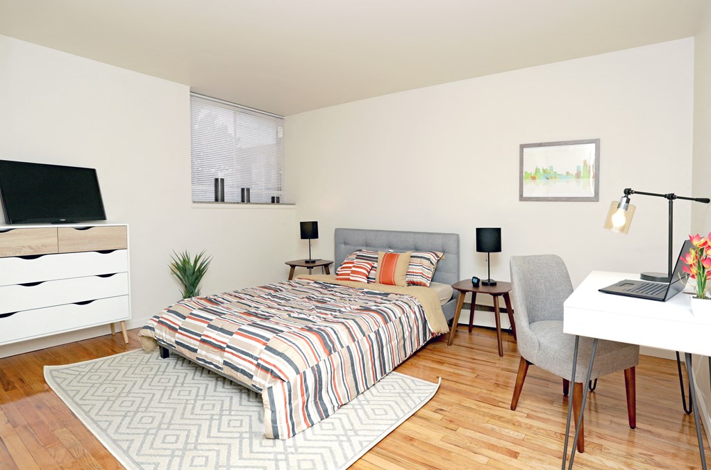 a bedroom with a bed and a desk with a computer