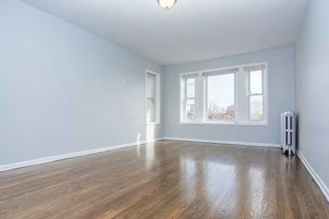 A room with wooden floors and a radiator on the wall.