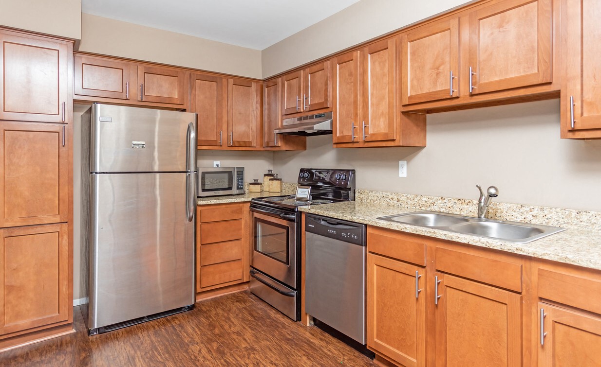 a kitchen with stainless steel appliances and wooden cabinets