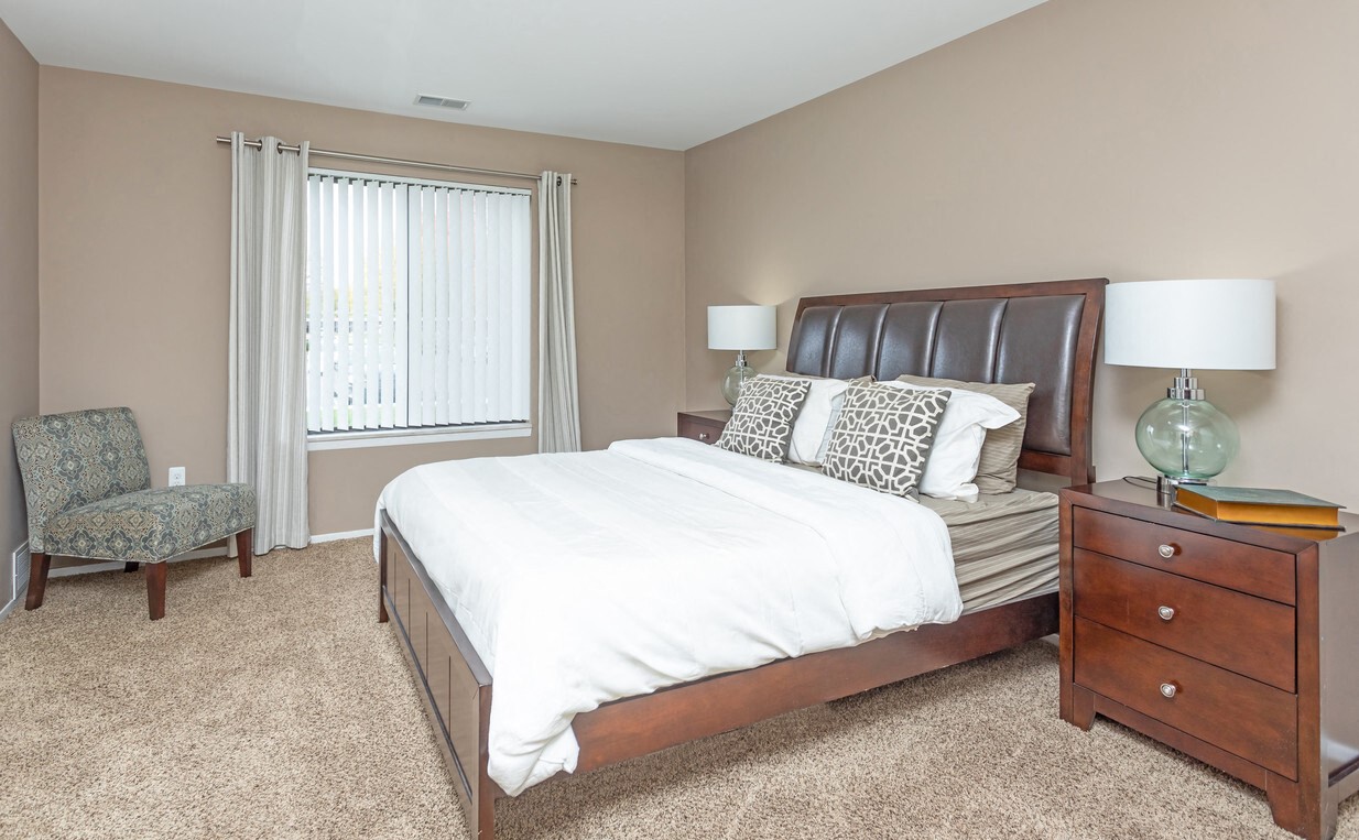 a bedroom with a bed and a dresser and a window