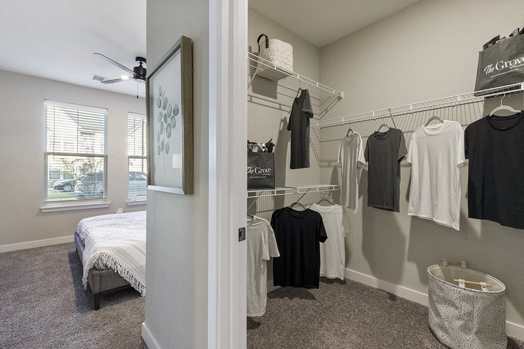a bedroom with a closet full of clothes and a bed